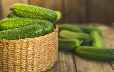 Taze salatalıklar kutuda ve eski ahşap masada. Seçici odak