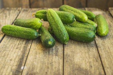 Eski ahşap masadaki taze salatalıklar.