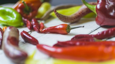 Eski beyaz ahşap masa üzerinde çeşitli renkli ve taze biber türleri (paprika).