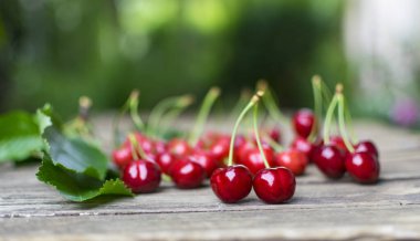 Yeni toplanmış, lezzetli kirazlar eski ahşap masada..