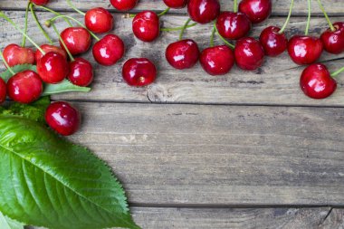 Kopya alanı olan eski ahşap masada taze toplanmış kirazlar. Yüksek açı görünümü.