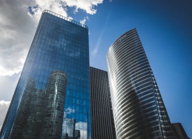 Paris, Fransa - 02 Ekim 2018: Gökdelen cam cepheleri açık güneşli bir günde mavi gökyüzünde güneş ışınları. Paris iş bölgesi La Defense 'daki modern binalar. Ekonomi, finans, iş faaliyeti konsepti. Alt görünüm.