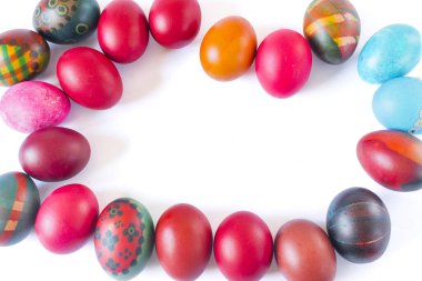 Renkli paskalya yumurtaları beyaz arkaplanda izole edilmiş bir çerçeve oluşturuyor.