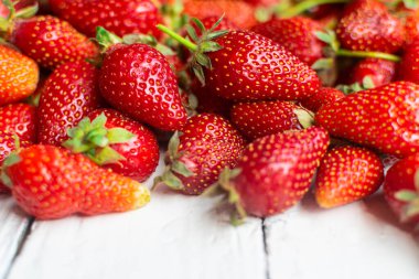 Taze, kırmızı çilekler eski beyaz masada, yazı için yeri var.