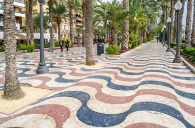 ALICANTE, İspanya - 27 Aralık 2018: İspanya 'nın en popüler yaya yollarından biri olan Alicante kentindeki bir gezinti alanı olan Paseo de la Explanada' da yürüyen insanlar.