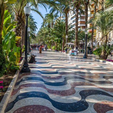 ALICANTE, İspanya - 30 Aralık 2018: İspanya 'nın en popüler yaya yollarından biri olan Alicante kentindeki bir gezinti alanı olan Paseo de la Explanada' da yürüyen insanlar.