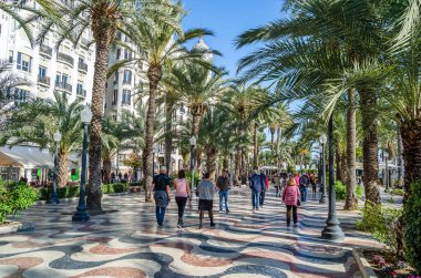 ALICANTE, İspanya - 30 Aralık 2018: İspanya 'nın en popüler yaya yollarından biri olan Alicante kentindeki bir gezinti alanı olan Paseo de la Explanada' da yürüyen insanlar.