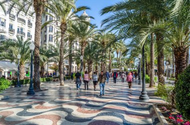 ALICANTE, İspanya - 30 Aralık 2018: İspanya 'nın en popüler yaya yollarından biri olan Alicante kentindeki bir gezinti alanı olan Paseo de la Explanada' da yürüyen insanlar.