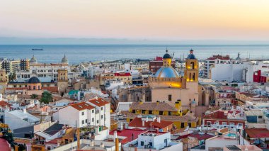 Alacakaranlıkta Alicante şehir manzarası, arka planda deniz olan katedrali gösteriyor