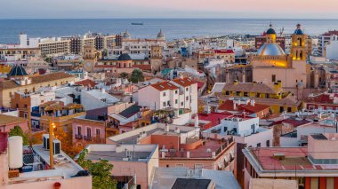 Alacakaranlıkta Alicante şehir manzarası, arka planda deniz olan katedrali gösteriyor