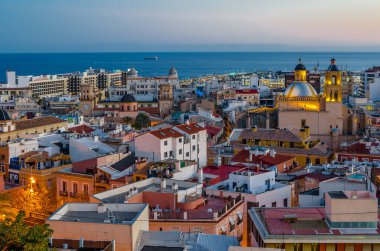 Alacakaranlıkta Alicante şehir manzarası, arka planda deniz olan katedrali gösteriyor