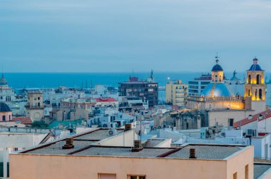 Alacakaranlıkta Alicante şehir manzarası, arka planda deniz olan katedrali gösteriyor