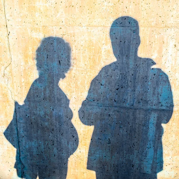 Shadow on a wall of a young couple with man and pregnant woman