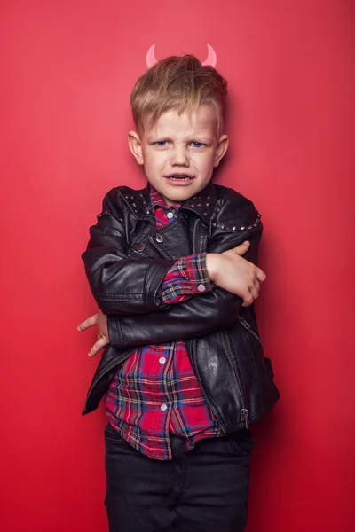 Diablillo guapo con cuernos y cola. Muchacho. Halloween. Estudio retrato aislado sobre fondo rojo — Foto de Stock