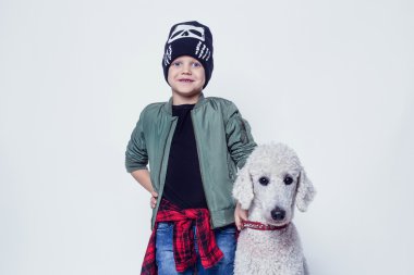 Yakışıklı çocuk Kraliyet fino köpeği ile. Moda. İnsan ve hayvan arasındaki dostluk. Beyaz arka plan üzerinde izole stüdyo portre