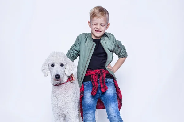 Um miúdo bonito com o Royal Poodle. Moda. Amizade entre pessoas e animais. Retrato de estúdio isolado sobre fundo branco — Fotografia de Stock