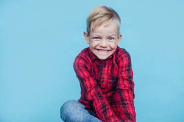 Kırmızı gömlek moda küçük çocuk. Moda. Stil. Stüdyo portre üzerinde mavi arka plan