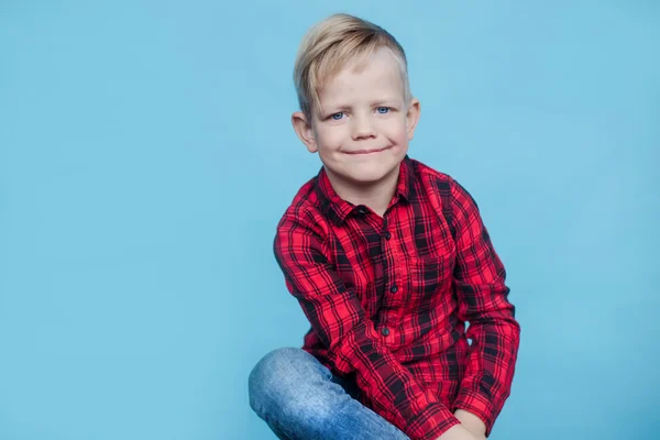 Fashionable little kid with red shirt. Fashion. Style. Studio portrait over blue background — Stock Photo, Image
