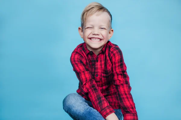 Menino bonito com camisa vermelha. Moda. Retrato de estúdio sobre fundo azul — Fotografia de Stock