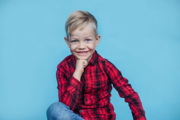 Handsome little boy with red shirt. Fashion. Studio portrait over blue background — Stock Photo, Image