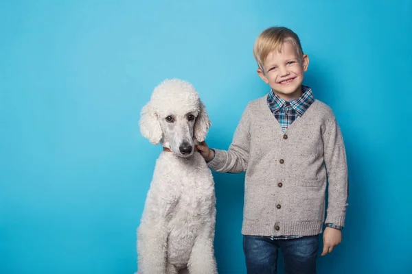 Модний хлопчик з собакою. Дружба. Домашні тварини. Студійний портрет на синьому фоні — стокове фото