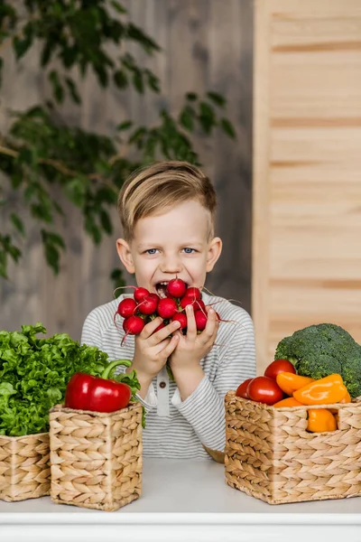 Guapo niño en la cocina comiendo verduras. Vegetariano. Alimento saludable — Foto de Stock