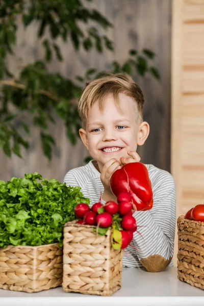 Guapo niño en la cocina comiendo verduras. Vegetariano. Alimento saludable — Foto de Stock