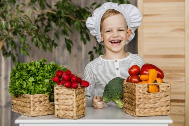 Şef sebze ile Tekdüzen şirin çocuk. Evde mutfak yemek. Vejetaryen. Sağlıklı gıda