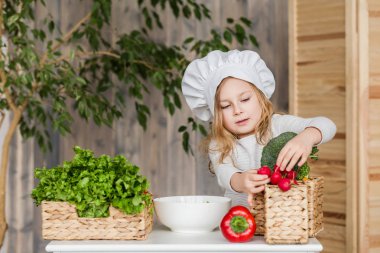 Küçük güzel kız mutfakta sebze salatası yapmak. Sağlıklı gıda. Küçük ev kadını