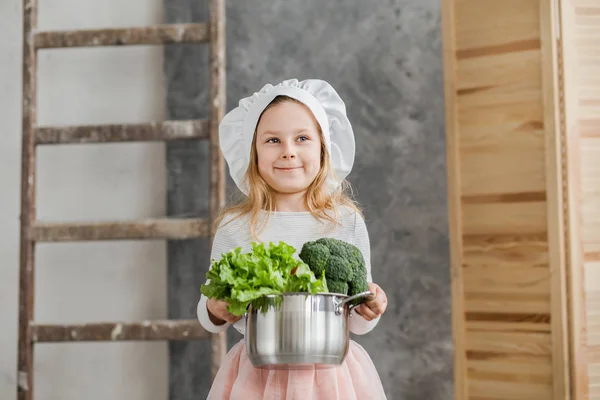 Pequena menina bonita segurando um pote cheio de legumes. Comida saudável. Colheita. Pequena dona de casa — Fotografia de Stock