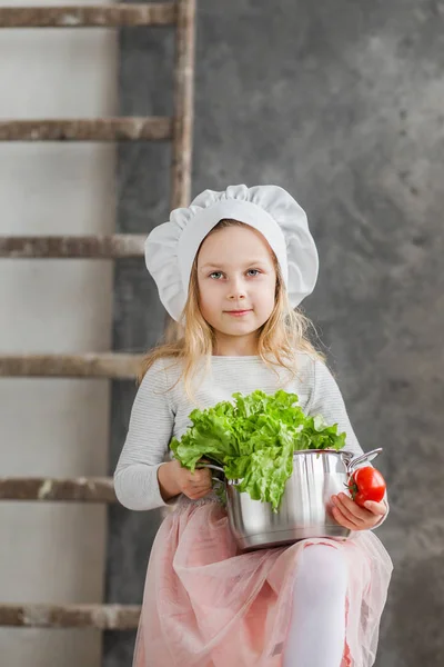 Piccola bella ragazza che tiene una pentola piena di verdure. Cibo sano. Vendemmia. Piccola casalinga — Foto Stock