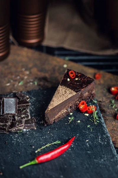 Piece of dark chocolate cake with red hot pepper. The restaurant or cafe atmosphere. Retro. Vintage