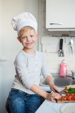 Çocuk Şef mutfakta evde yemek yapıyor. Sağlıklı gıda