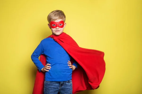 赤のスーパー ヒーロー マントとマスクの少年。スーパーマン。黄色の背景の上のスタジオ ポートレート — ストック写真