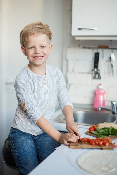 ハンサムな男の子は自宅のキッチンで料理しています。健康食品 — ストック写真