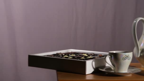 Set de té en la mesa con caramelos de chocolate — Vídeos de Stock