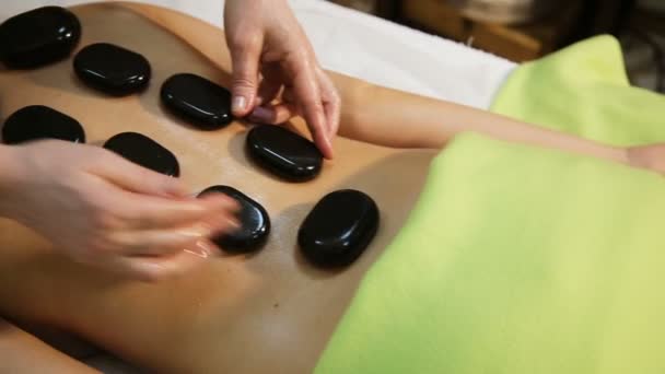 Woman in spa salon with hot stones — Stock Video