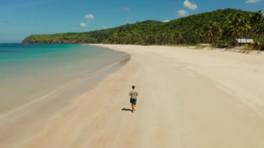 Yazın sahilde koşan bir adam.