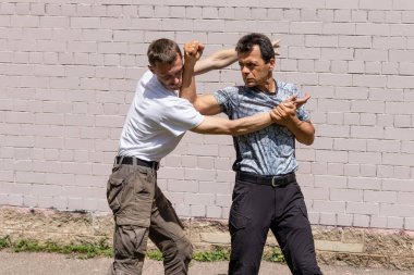 Dövüş sanatları eğitmenleri Krav Maga sokak dövüşlerinde kendini savunma tekniklerini gösterirler. - Evet. Savunma, saldırganın elini engeller ve karşı saldırıya geçer.