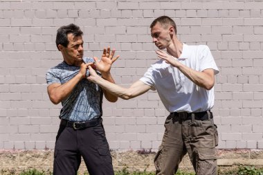 Dövüş sanatları eğitmenleri Krav Maga sokak dövüşlerinde kendini savunma tekniklerini gösterirler. Saldırgan, adamı giysilerinden yakalayıp...