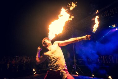 Genç erkek sanatçı, yakın plan ateş püskürtür. Yaz açık hava festivalinde yangın gösterisi