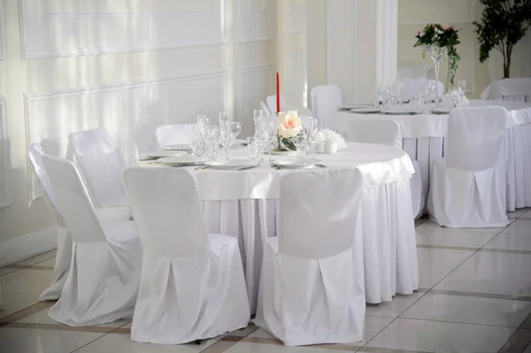 Τραπέζι με καρέκλες που καλύπτονται και λευκό τραπεζομάντηλο. — Φωτογραφία Αρχείου