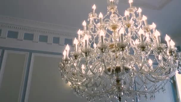 Luxo grande lustre de cristal pendurado no palácio . — Vídeo de Stock