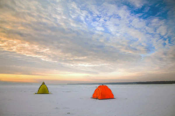 Bright tents camping of the expedition on ice of the Northernat sunset.
