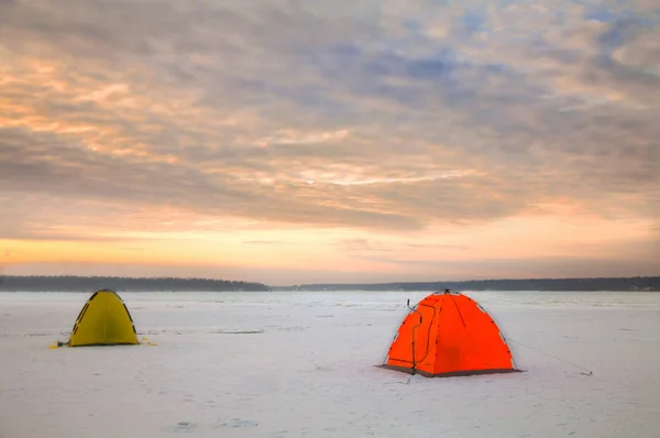 Bright tents camping of the expedition on the ice of the Northernat sunset.