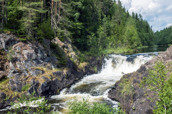 Waterfall powerful on rocks in wild nature.