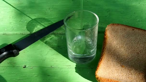 В пустой стакан налейте водку на стол из выветриваемых досок . — стоковое видео