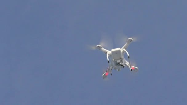 Quadcopter is flying high in the blue sky. — Stock Video