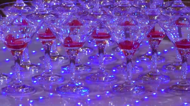 Skleničky na šampaňské ve světle světel. Vinná pyramida pro večírky.