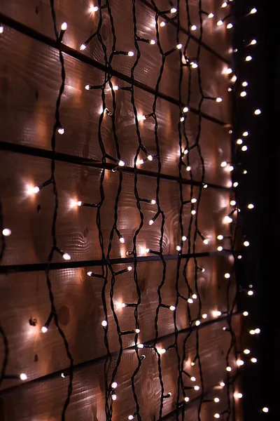 Wooden wall with Christmas garlands. — Stock Photo, Image